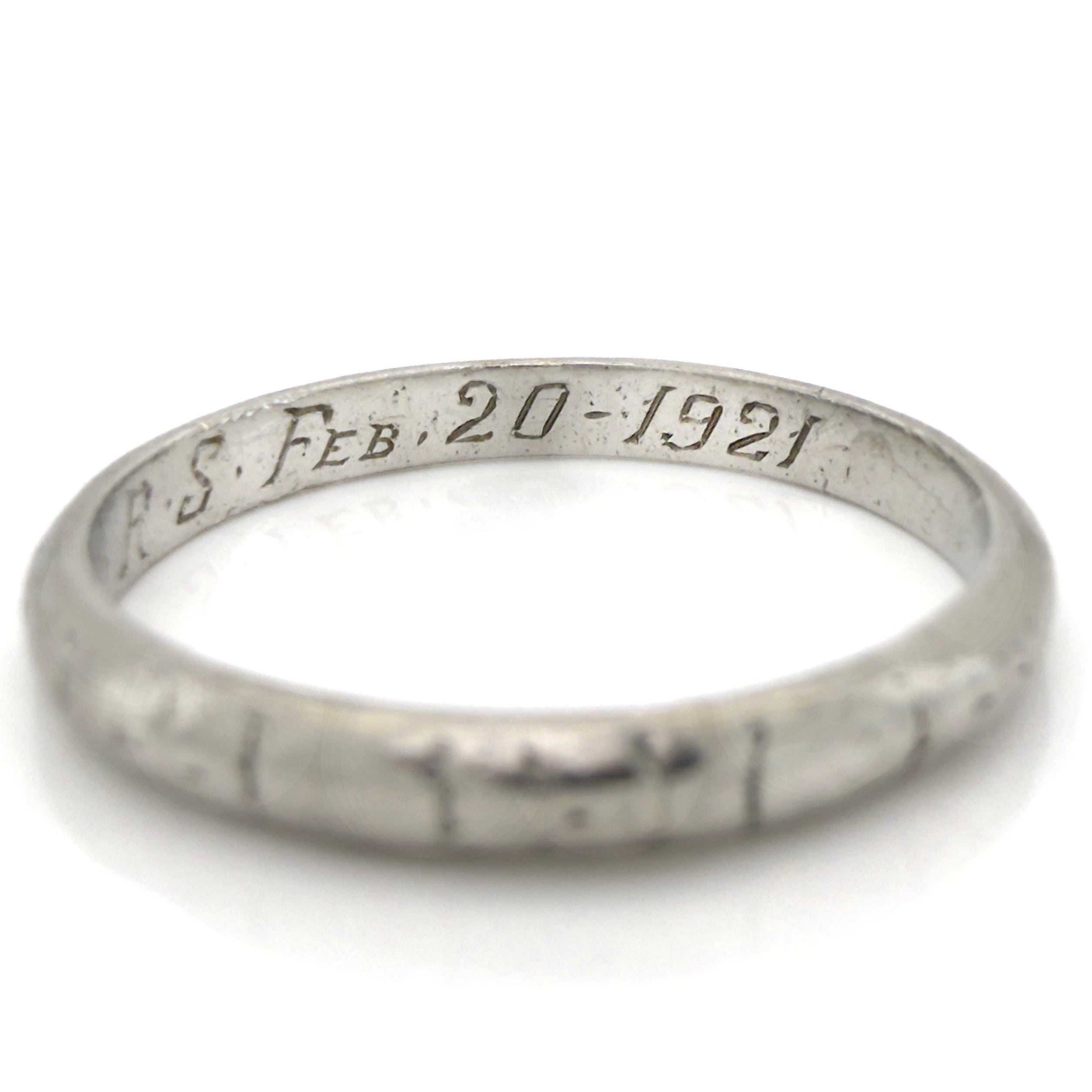 Art Deco platinum ring with engraved text on a white background