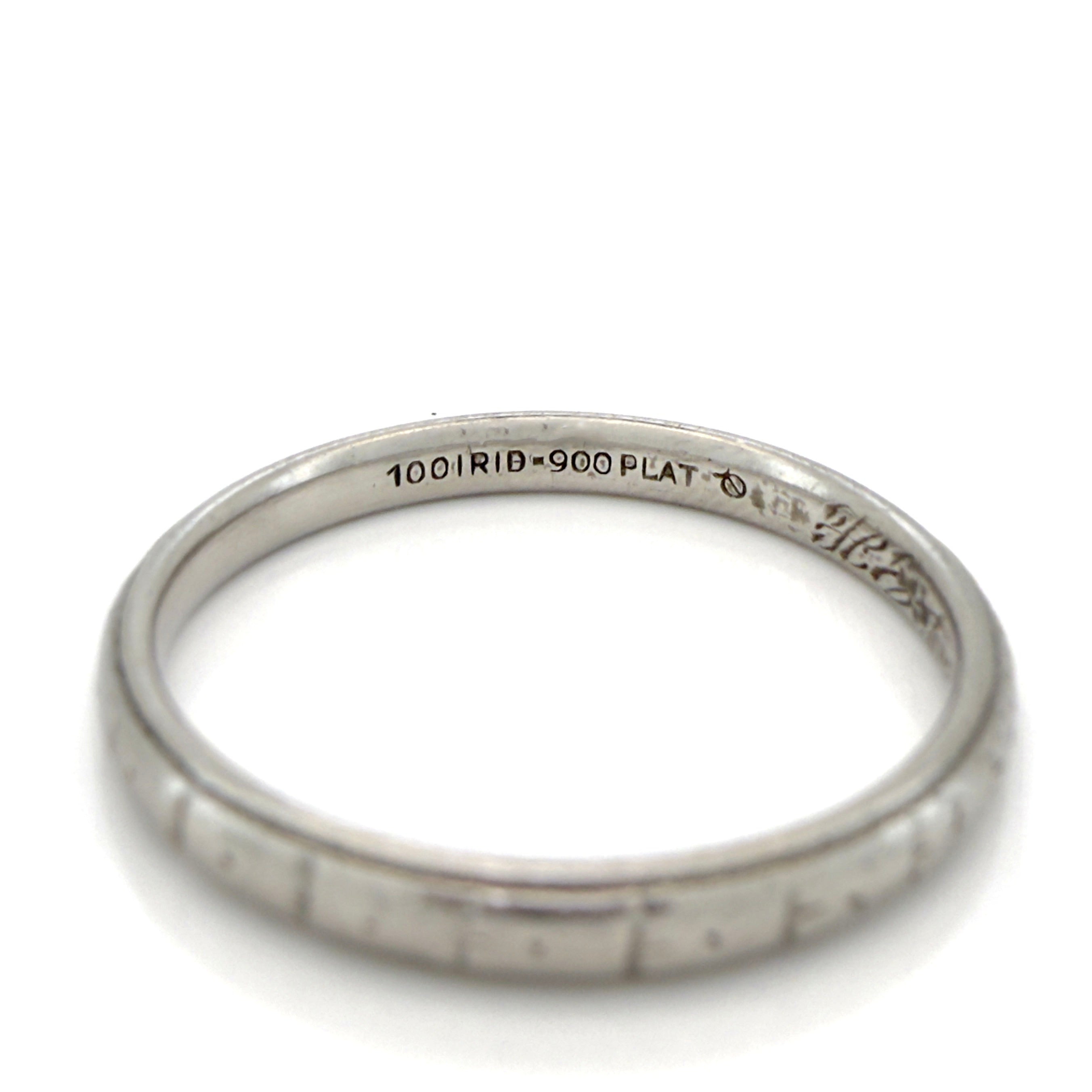 Antique platinum ring with engraved design on a white background