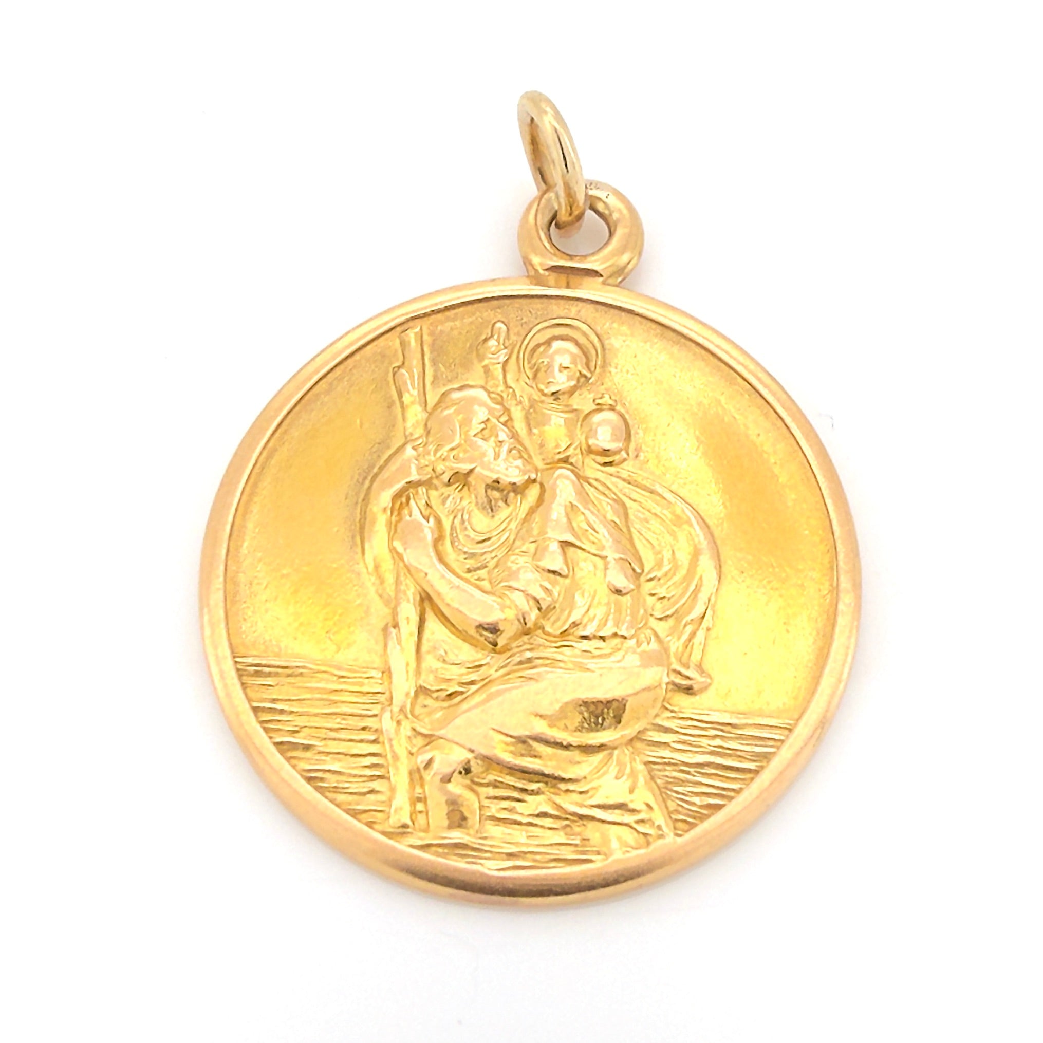 Vintage gold pendant with religious design on a white background