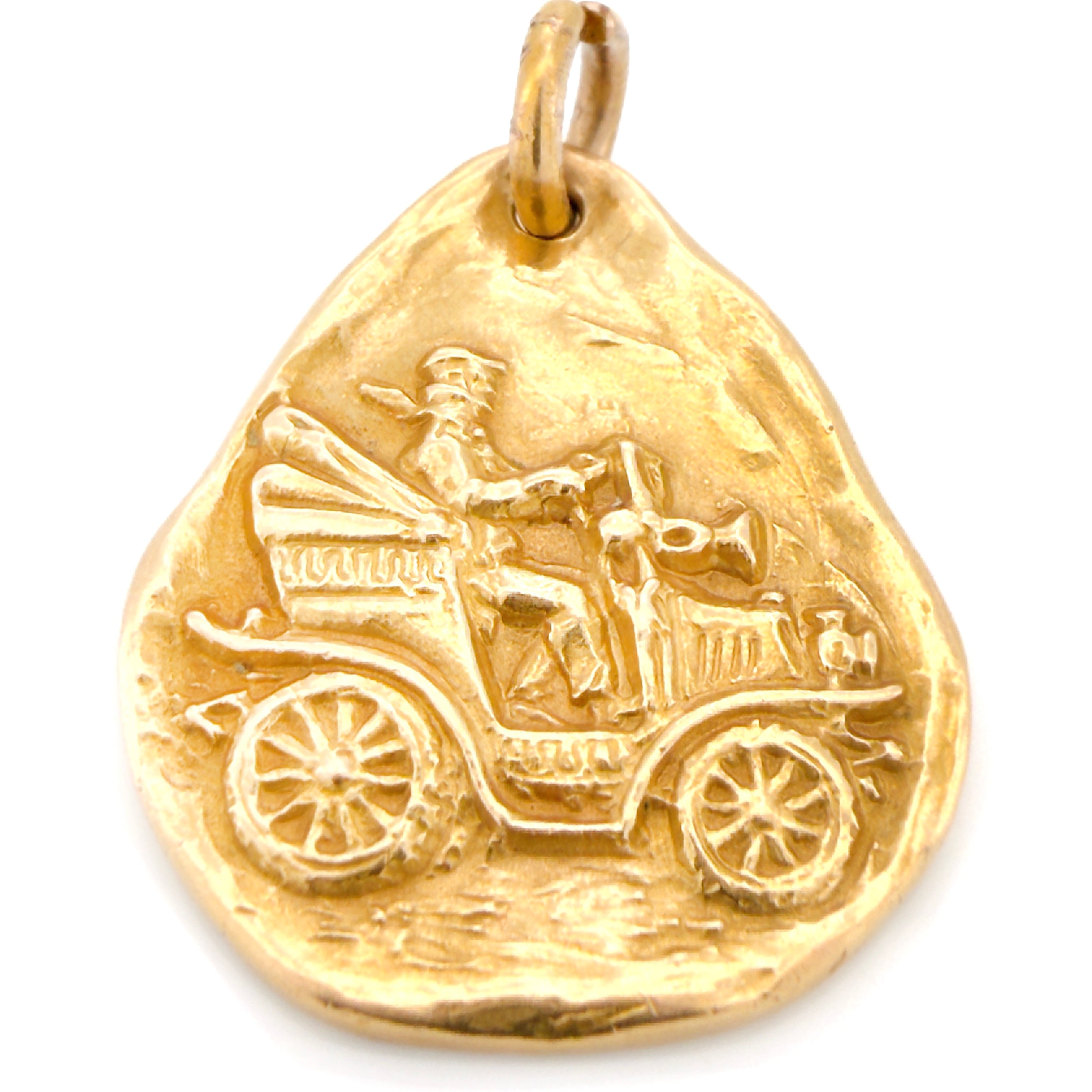 Gold pendant with vintage car design on a white background.