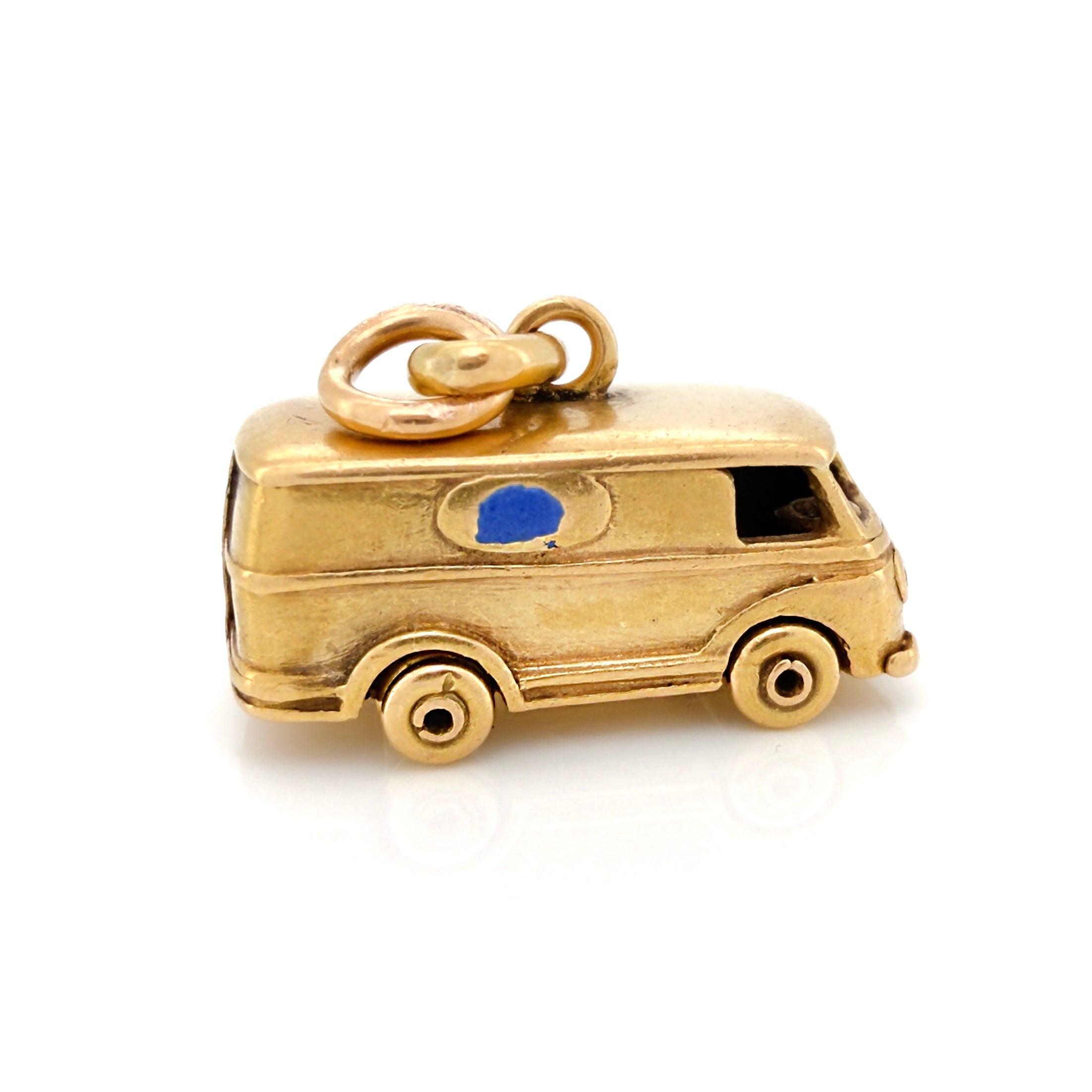 Vintage gold microbus  charm with a light blue enamel window on a white background
