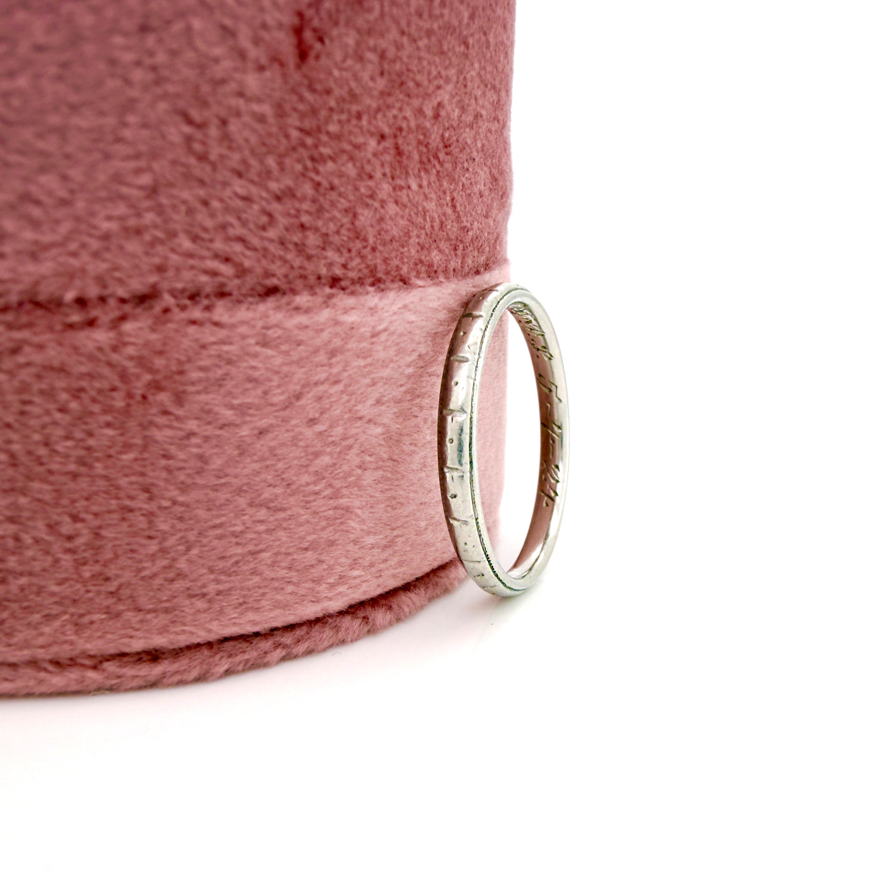 Platinum ring on a pink fabric background