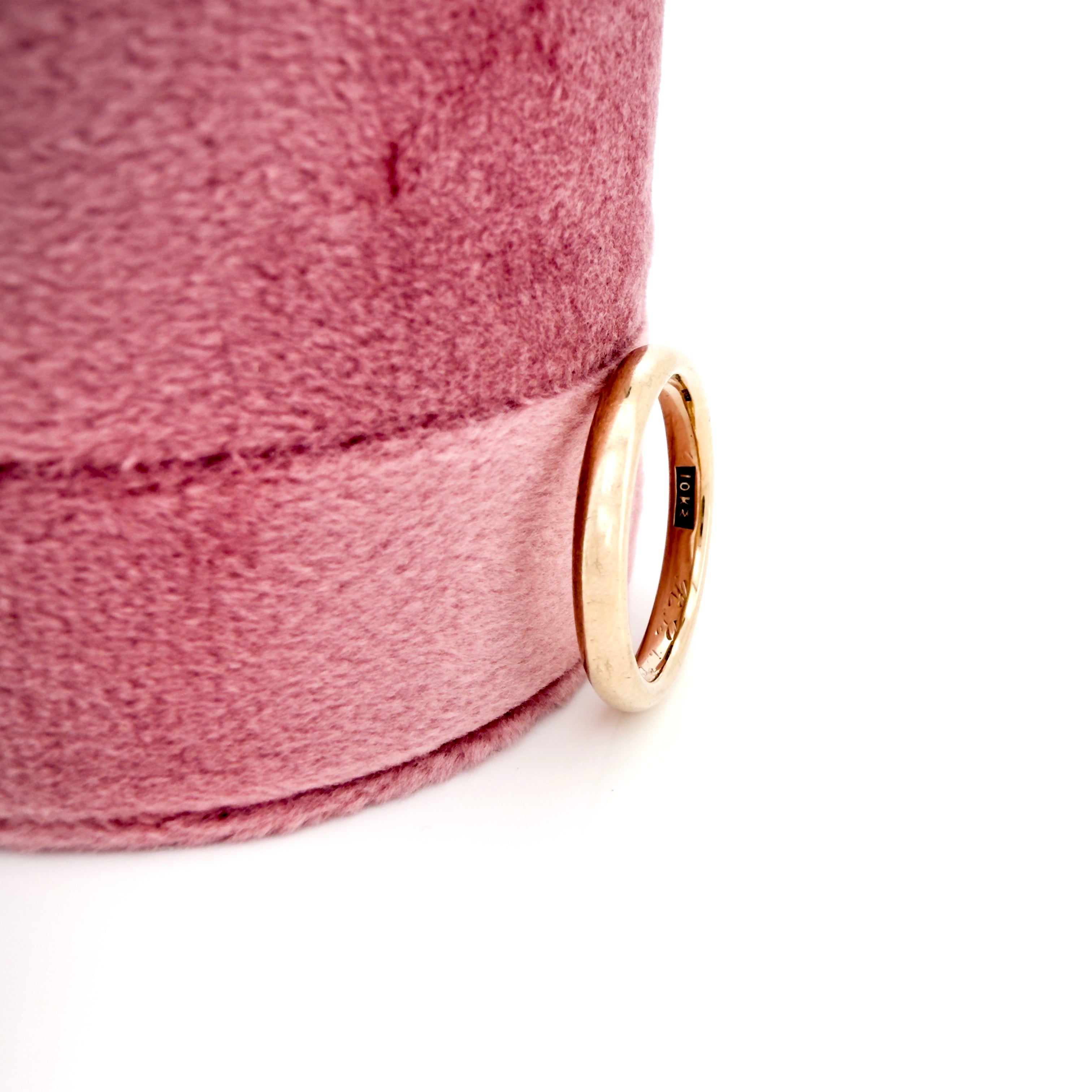 Gold ring on a pink fabric background