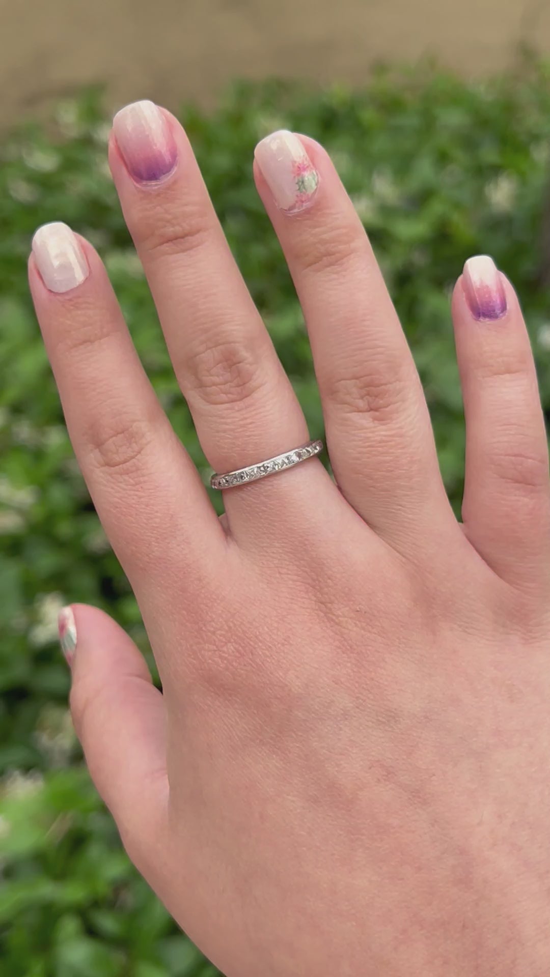 Hand wearing an Art Deco french cut diamond band made out of platinum