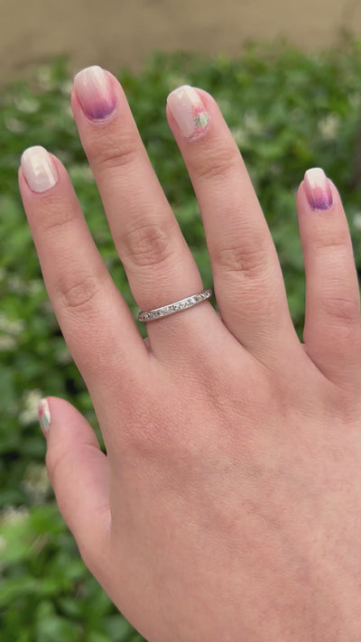 Hand wearing an Art Deco french cut diamond band made out of platinum